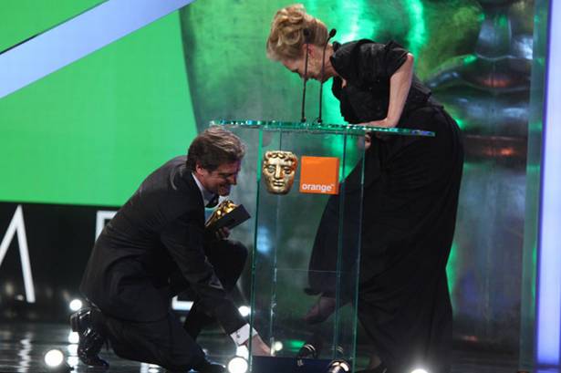 Colin+Firth+hands+Meryl+Streep+her+shoe+after+it+fell+off+on+her+way+to+the+stage